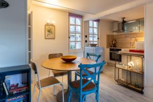 uma cozinha e sala de jantar com mesa e cadeiras em La maison Confidentielle - plein centre historique - 2 chambres - 4 pers em Honfleur