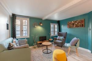 uma sala de estar com um sofá e cadeiras em La maison Confidentielle - plein centre historique - 2 chambres - 4 pers em Honfleur