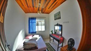 a room with a bed and a mirror and a desk at Ecohostel Dos Canyons Santa Catarina in Praia Grande