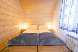 Łóżko lub łóżka w pokoju w obiekcie DW KINGA & DOMKI na Granicznej z jacuzzi