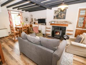 a living room with a couch and a fireplace at Glascoed in Pwllheli