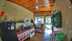 a kitchen with a refrigerator and a stove in it at Ecohostel Dos Canyons Santa Catarina in Praia Grande