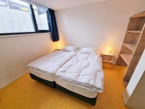 A bed or beds in a room at NIEUW DOMBURG centrum - Luxe vakantiewoning 500 meter van strand met tuin en parkeerplaats & WIFI - Roosjesweg 2A