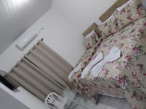 Un dormitorio con una cama con flores rosas. en Apto para até 6 pessoas, 600 metros da Basílica en Aparecida