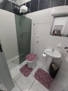 a bathroom with a shower and a toilet and a sink at Apto para até 6 pessoas, 600 metros da Basílica in Aparecida