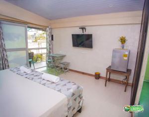 - une chambre avec un lit et une télévision murale dans l'établissement AMAZONAS EXPLORERS LETICIA, à Leticia