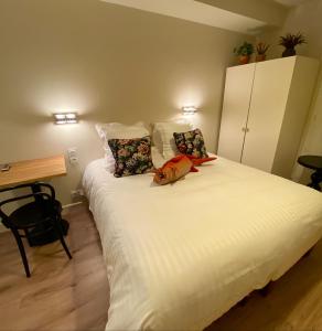 een slaapkamer met een groot wit bed met 2 kussens bij Hôtel Les Bains in Saint-Valéry-en-Caux