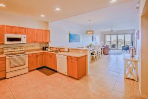 a large kitchen with wooden cabinets and a dining room at Beautiful waterfront 3 bedroom condo, located in the heart of Clearwater Beach in Clearwater Beach