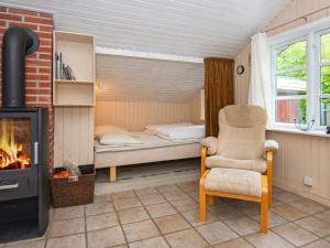 a bedroom with a bed and a chair and a fireplace at 4 person holiday home in Hemmet in Hemmet