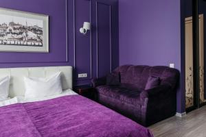 ein lila Schlafzimmer mit einem Bett und einem Sofa in der Unterkunft Marel Hotel in Sankt Petersburg