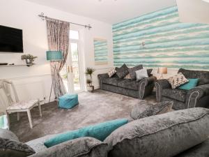 a living room with two couches and a large painting on the wall at St Cuthbert's Cottage in Beal