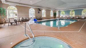 - une piscine avec des chaises et des tables dans un bâtiment dans l'établissement Best Western Plus River Escape Sylva / Dillsboro, à Dillsboro