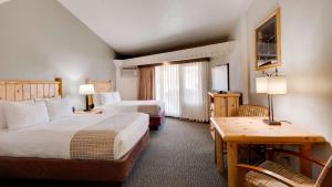 a hotel room with two beds and a desk at Best Western East Zion Thunderbird Lodge in Mount Carmel Junction