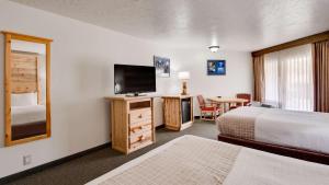 a hotel room with two beds and a flat screen tv at Best Western East Zion Thunderbird Lodge in Mount Carmel Junction