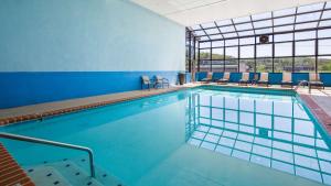 a large swimming pool with blue walls and windows at Best Western Dayton in Dayton