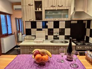 a kitchen with a bowl of fruit and a bottle of wine at Apartmani Ristić in Niška Banja