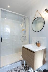 uma casa de banho com um chuveiro, um lavatório e um espelho. em Vert d'Hotes - Charming renovated apartment - downtown - WIFI - em Honfleur