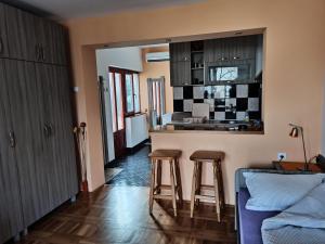 a kitchen with two bar stools and a counter top at Apartmani Ristić in Niška Banja