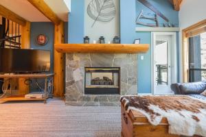 a living room with a fireplace and blue walls at Powderhorn by Outpost Whistler in Whistler
