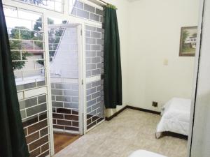 a room with a brick wall and a window at Hotel Veritas in Guarapuava