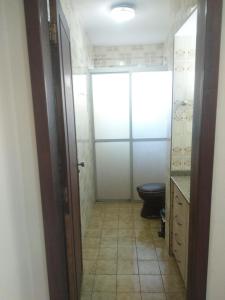a bathroom with a toilet and a sink and a door at Hotel Veritas in Guarapuava