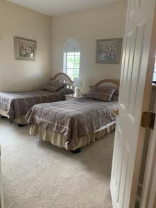 1 dormitorio con 2 camas y ventana en Orlando Vacation Villa en Orlando