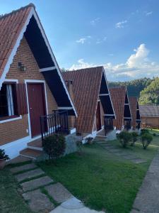 a row of houses with a red roof at Chalés Paraíso Monte Verde in Monte Verde