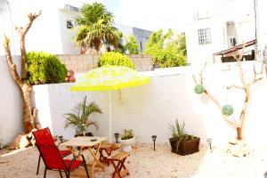 a patio with a table and a yellow umbrella at Apartamento privado, NUEVO Rooftop, AC, GRAN WF in Cancún