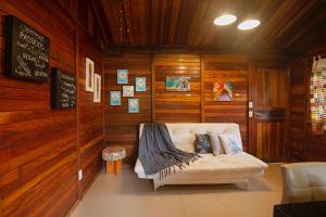 sala de estar con sofá en una habitación con paredes de madera en Casinha de Madeira no Vale do Capão, en Vale do Capao