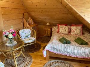 a bedroom with a bed in a log cabin at Willa Pod Strzechą in Wiartel Mały