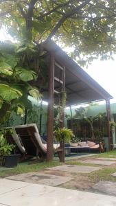 a pavilion with chairs and a table and trees at Enjoy Hostel e Pousada in Aracaju