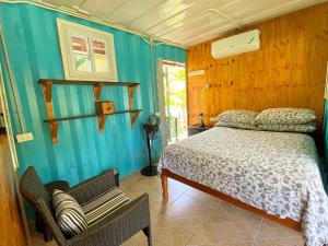 1 dormitorio con cama y pared azul en Judy House Backpacker Hostel, en Little Bay