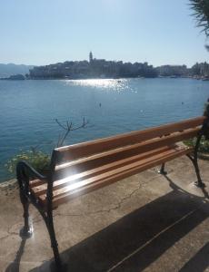 a bench sitting next to a body of water at Blaga Apartment - in Korčula