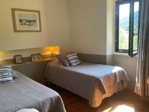 1 dormitorio con 2 camas y ventana en Stylish house with heated pool in Lacoste, en Lacoste