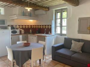 uma cozinha e sala de estar com uma mesa e um sofá em Stylish house with heated pool in Lacoste em Lacoste