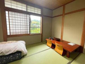 a bedroom with a table and chairs and a bed at Guest House Nakamura in Ama