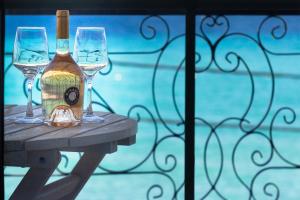 a bottle of wine and two glasses on a table at Alkionides Rooms in Polychrono