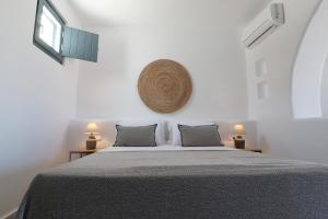 a white bedroom with a bed and two lamps at Archon Seaside Retreat in Plaka