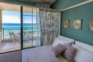 a bedroom with a bed and a view of the ocean at Alkionides Rooms in Polychrono