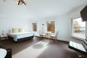 - une chambre avec un lit, une table et des chaises dans l'établissement Salamanca Galleria Apartments, à Hobart