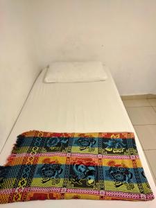 białe łóżko z kolorowym dywanem w obiekcie Mz Hotel Official Account w mieście Skudai