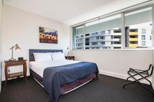 a bedroom with a bed and a large window at Ridge Apartment Hotel in Brisbane