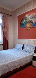 ein Schlafzimmer mit einem Bett und einem Wandgemälde in der Unterkunft 2-комнатная с раздельнвми комнатами, Центр in Dnipro