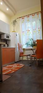 eine Küche mit einem Tisch und Stühlen sowie einem Kühlschrank in der Unterkunft 2-комнатная с раздельнвми комнатами, Центр in Dnipro