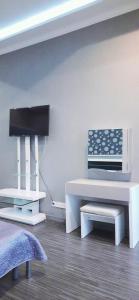ein Wohnzimmer mit weißen Möbeln und einem TV in der Unterkunft 2-комнатная с раздельнвми комнатами, Центр in Dnipro