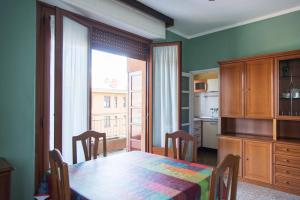 jadalnia ze stołem i dużym oknem w obiekcie YouHosty - Suzzani 269 w Mediolanie