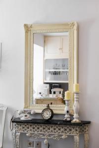 a mirror on top of a table with a clock at Galaxa Mansion in Galaxidhion