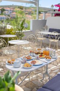 einen Tisch voller Teller mit Speisen auf einer Terrasse in der Unterkunft Galaxa Mansion in Galaxidi