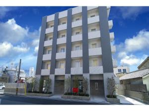 和歌山HOTEL LASCALA的街边的一栋高大的白色建筑