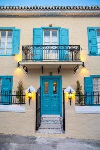 budynek z niebieskimi drzwiami i balkonem w obiekcie Galaxa Mansion w mieście Galaxidi